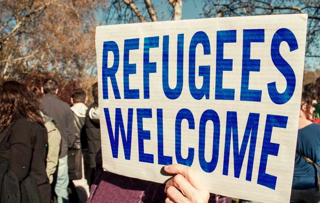 a placard saying refugee welcome